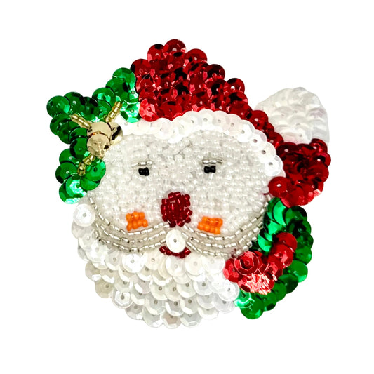 A festive sequined Santa Claus face patch on a white background. The design features a Beige beaded beard and face, red sequins for the hat and nose, green sequins for the leaves, and small orange accents for the cheeks.
