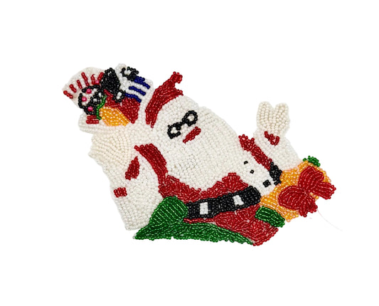 A hand-beaded decorative patch or applique featuring a stylized Santa Claus face and holiday motifs, crafted with white, red, green, yellow, black, and blue beads on a plain white background.