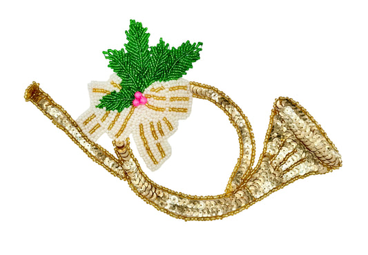 A decorative embroidered patch shaped like a trumpet or horn, with a gold sequined body, a white beaded bow, green holly leaves, and a small pink center, shown on a plain white background.