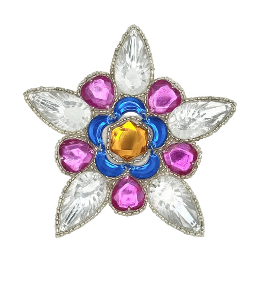 A decorative flower-shaped beaded appliqué  with a silver glass beads, featuring a central gold gem, surrounded by blue and magenta stones, and five clear teardrop-shaped crystals.