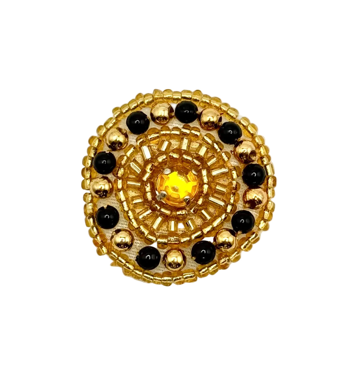 A round gold-tone beaded patch or decorative button with a central yellow crystal and alternating black and gold beads, shown on a plain white background.