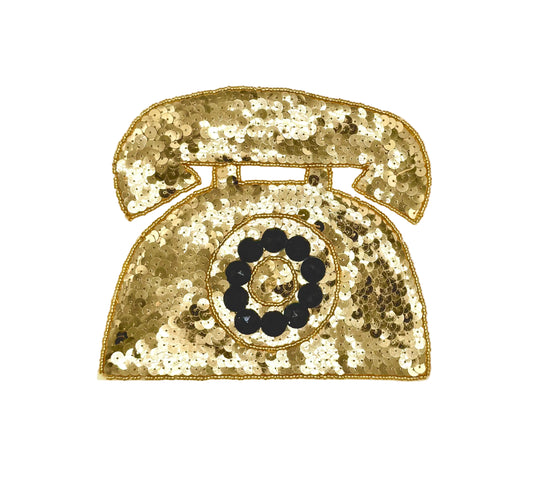 A vintage rotary telephone patch embellished with gold sequins and black circular details, shown on a plain white background.