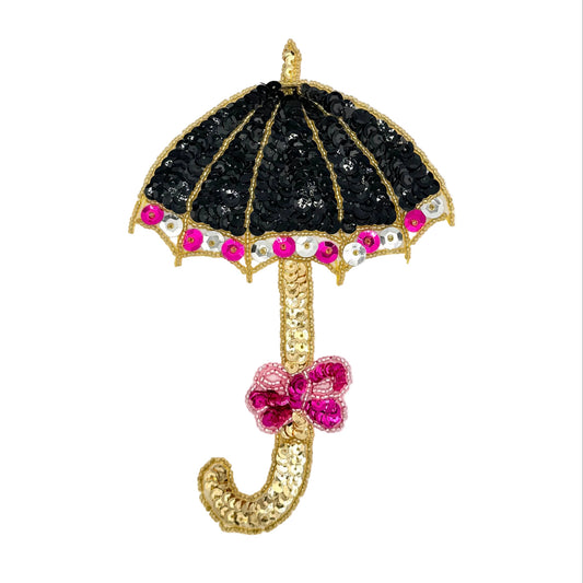 A decorative umbrella-shaped embellishment with a black sequined canopy, gold-tone trim and handle, and bright pink sequin and bead accents, shown on a plain light background.