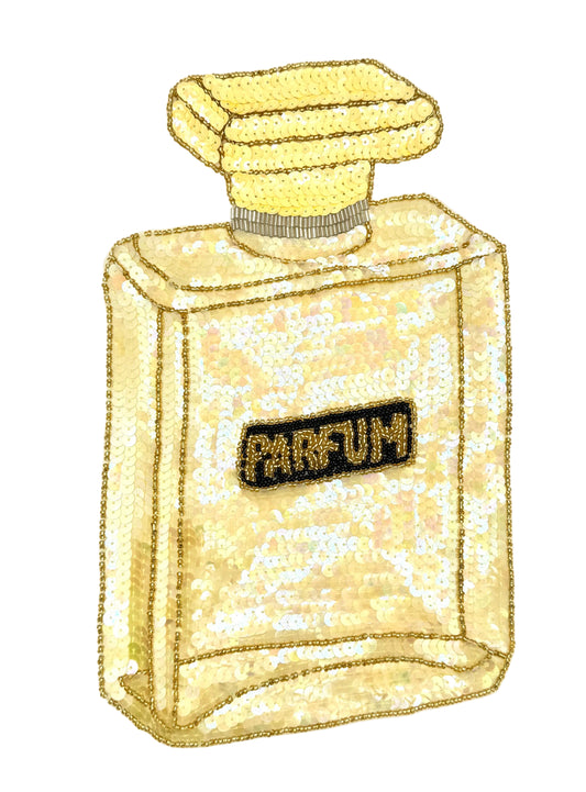 A sequin perfume bottle with airiedescent yellow and yellow sequins, featuring a black label with the word 'PARFUM' in gold bead lettering, set against a plain white background.