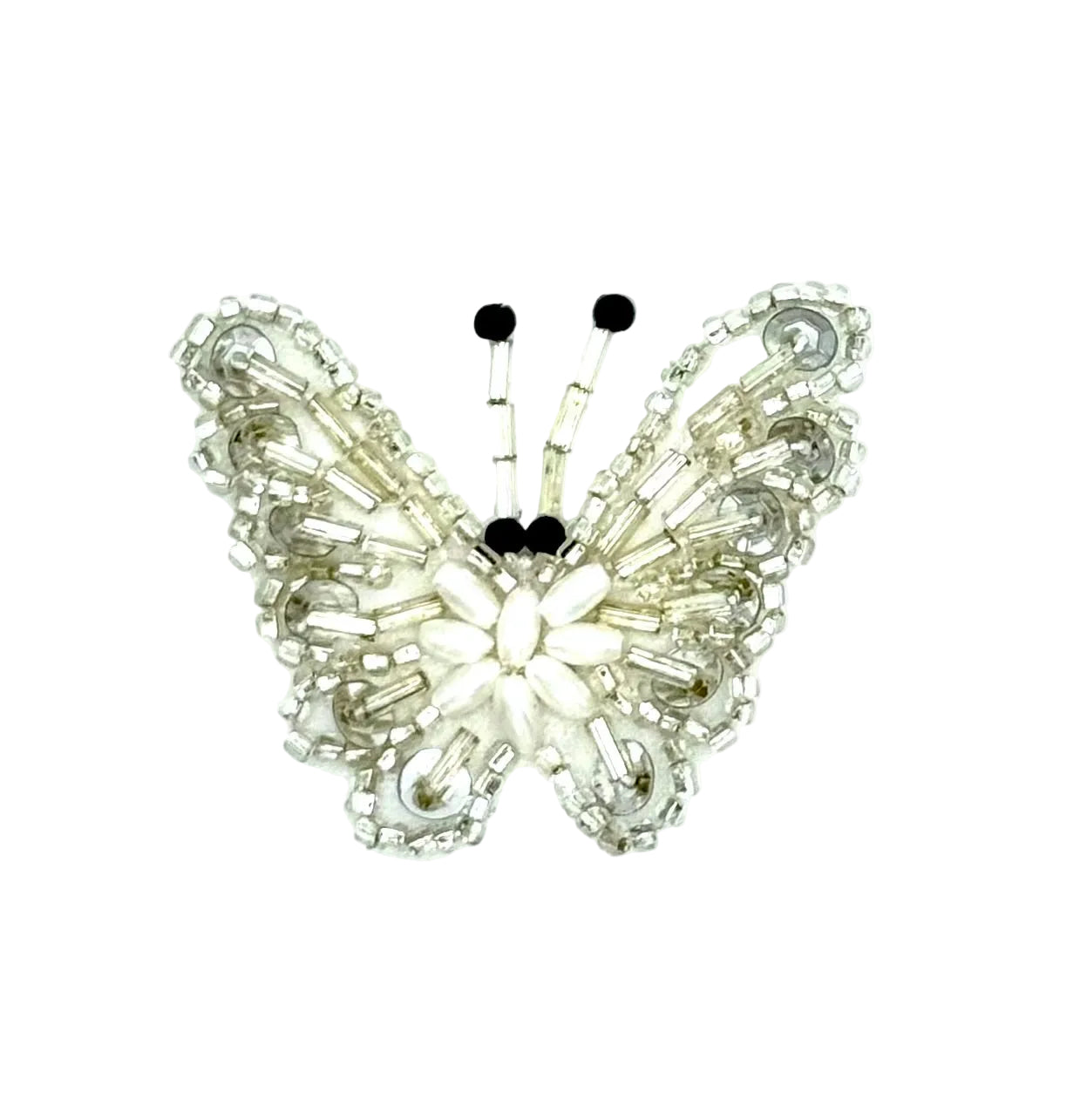 A butterfly-shaped appliqué made with silver sequins and beads and small black bead antennae, centered on a plain white background.