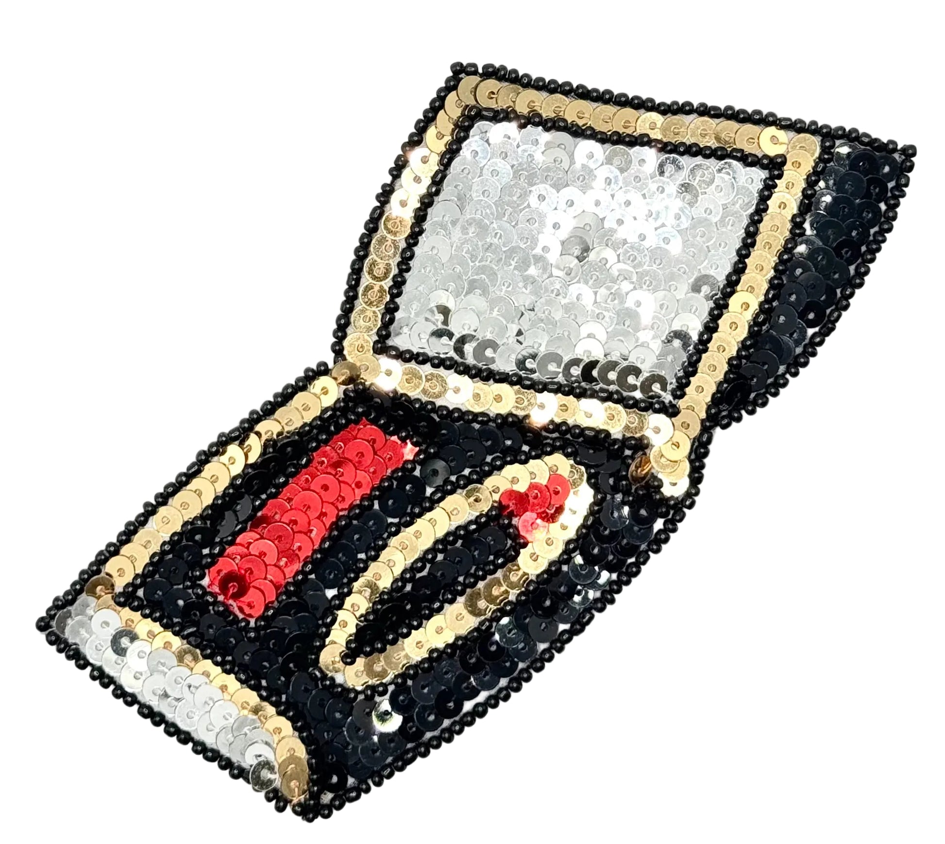 A sequined makeup compact open on a plain white background. The exterior is covered in black, silver, and gold sequins, while the interior features a red sequined makeup slot and a gold makeup slot.