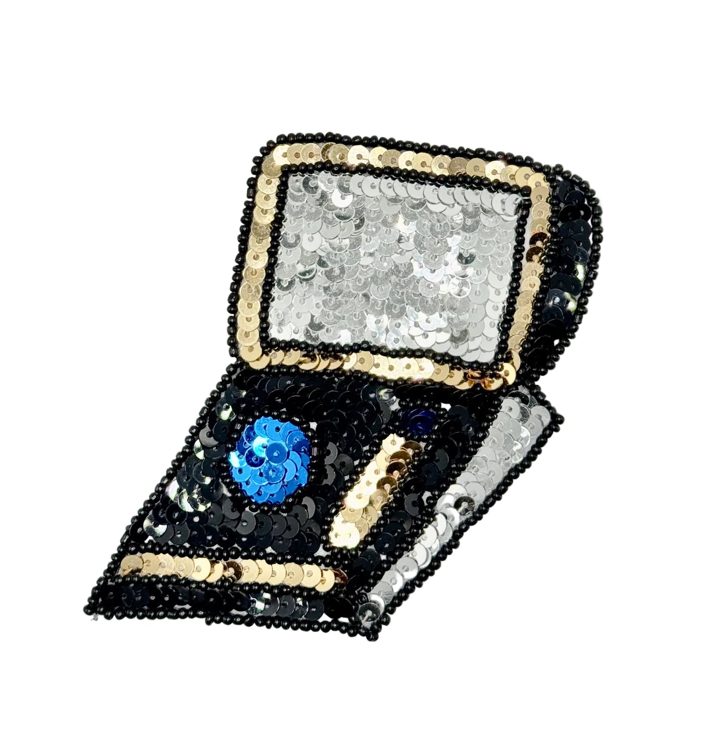 A sequined makeup compact open on a plain white background. The exterior is covered in black, silver, and gold sequins, while the interior features a blue sequined makeup slot and a gold makeup slot.