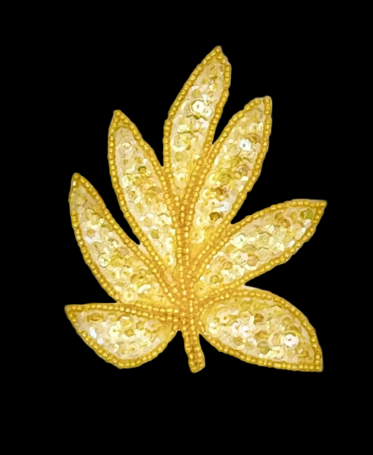 A iridescent yellow sequined leaf-shaped embellishment or patch on a plain white background.