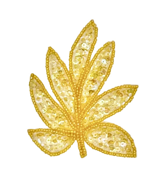 A iridescent yellow sequined leaf-shaped embellishment or patch on a plain white background.