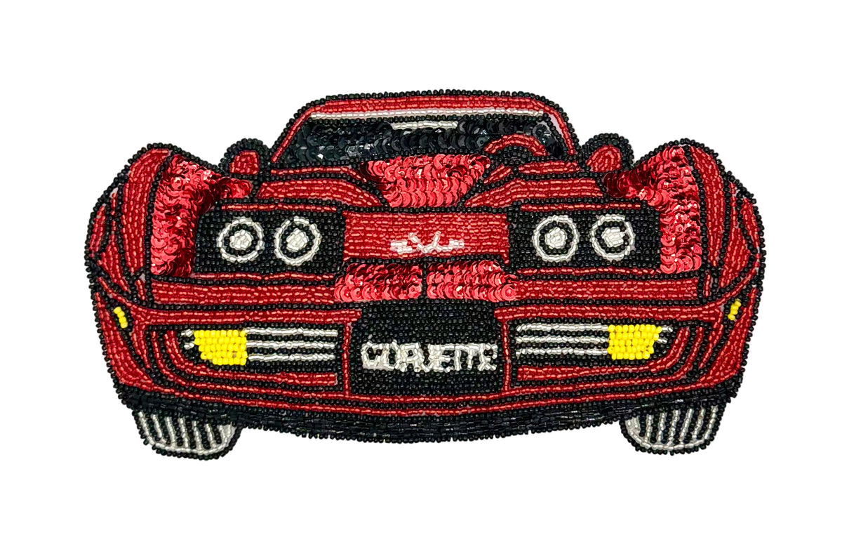 A vintage red sequin patch shaped like a Corvette sports car, featuring black outlines, white circular headlights, yellow light accents,  shown on a plain white background.