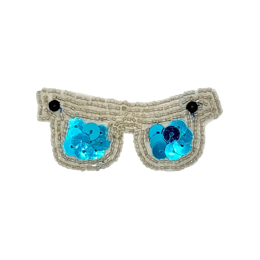 A pair of novelty sunglasses with silver beaded frames, turquoise sequined lenses, and small black round embellishments, shown on a plain white background.