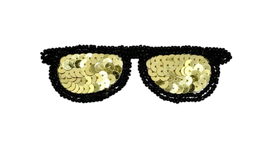 Black beaded sunglasses costume accessory with gold sequin lenses on a plain white background.