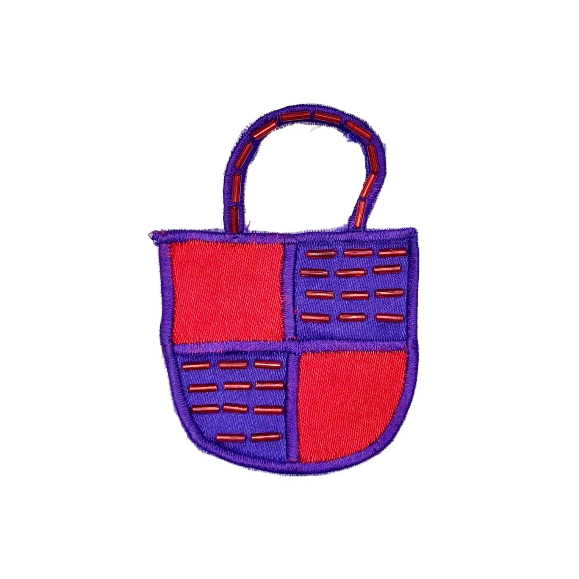 A small embroidered patch shaped like a handbag, with a purple border and handle, divided into four red and purple sections with stitched red bead details, shown on a plain white background.
