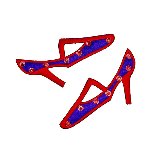 A pair of red and purple high-heeled shoe-shaped embellishments decorated with red sequins and beads, shown on a plain white background.
