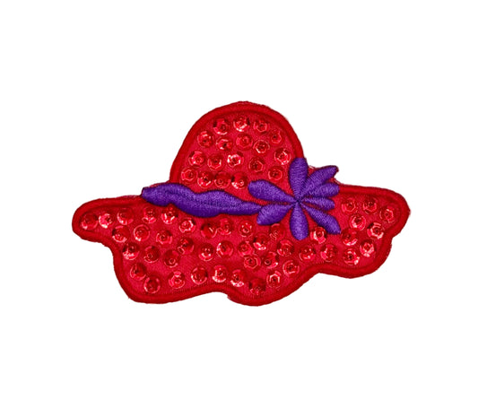 A red embroidered and sequined hat-shaped applique patch with a purple ribbon and purple flower accent, shown on a plain white background.