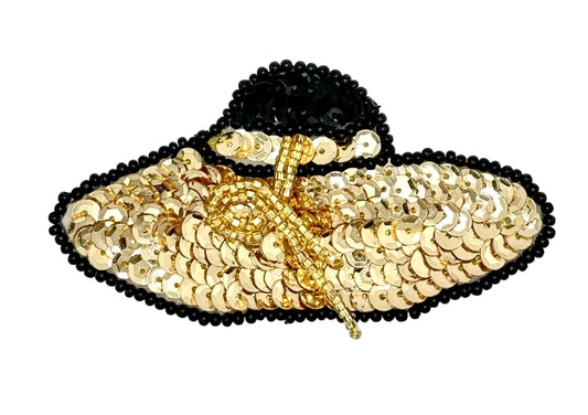 A decorative embellished hat applique featuring a black sequined brim and crown, a gold sequined crown and bow, and a black beaded edge, shown on a plain white background.