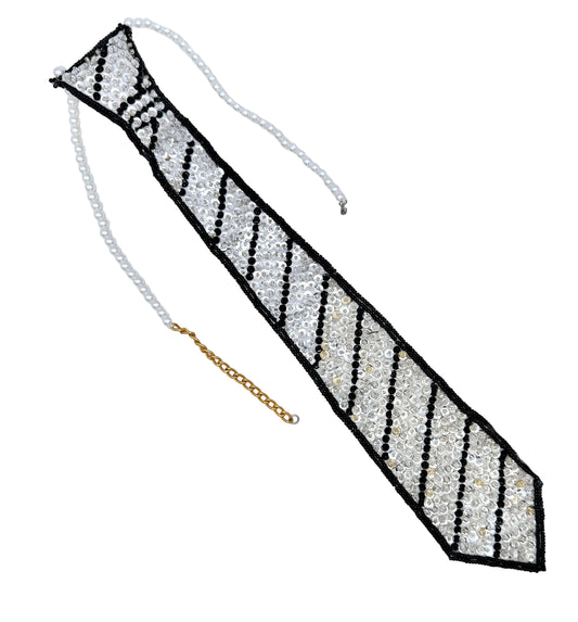 A novelty necktie accessory made of white faux pearls and black and white sequins and beads, with a gold chain extender, displayed on a plain white background.