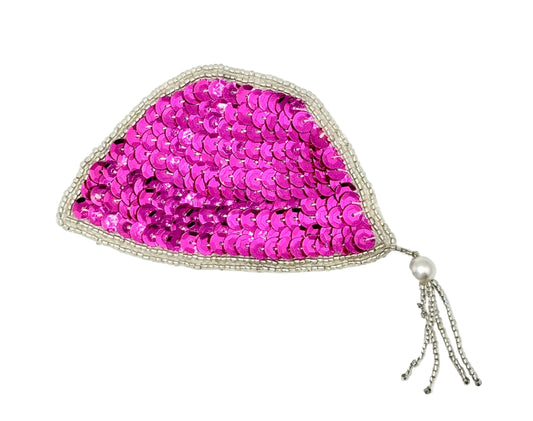 A sequin cap patch with a tassel. Fuchsia sequins and silver beads and a dangling silver beaded chain with a pearl accent, shown on a plain white background.