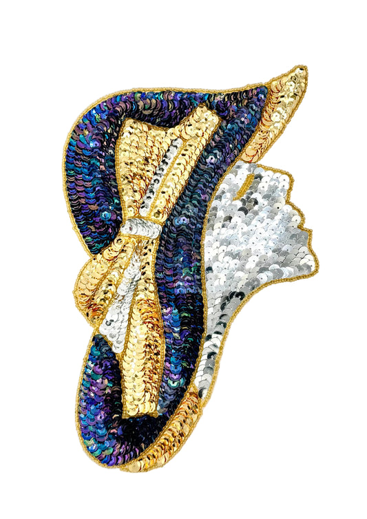 A decorative patch shaped like a woman's profile wearing a hat, covered in iridescent blue and purple sequins with gold trim, a gold bow, and a white sequined face area, shown on a plain light background.