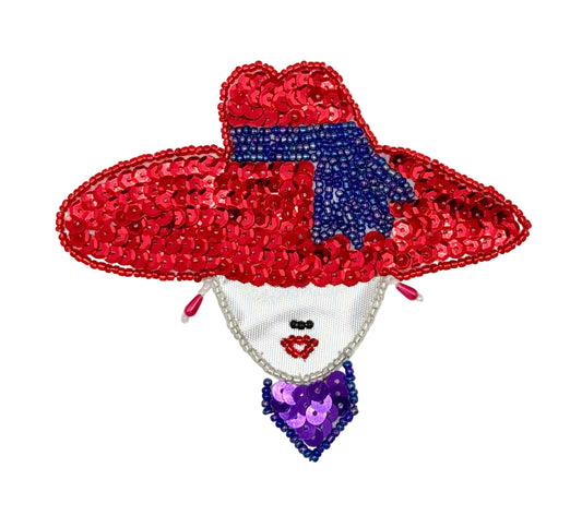 A decorative sequin patch shaped like a woman's face wearing a large red sequined hat with a blue bow, a silver face area, and a purple sequined bow tie, shown on a plain white background.