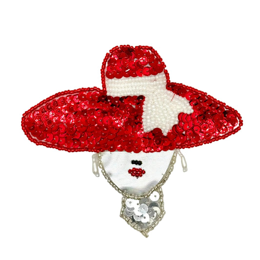 A decorative sequin patch shaped like a woman's face wearing a large red sequined hat with a white bow, on a plain white background.