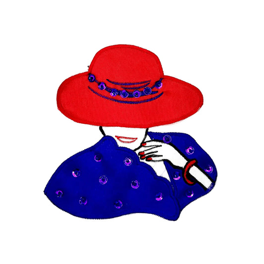 A stylized embroidered patch of a woman wearing a bright red wide-brim hat with purple sequin and bead trim and a purple cape with purple sequins and beads, on a plain white background.