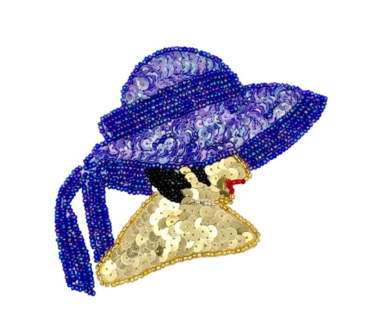 A decorative patch or applique shaped like a woman's profile wearing a large hat, made from iridescent purple sequins and beads, gold sequins, hair in black beads and small red lips on a plain white background.