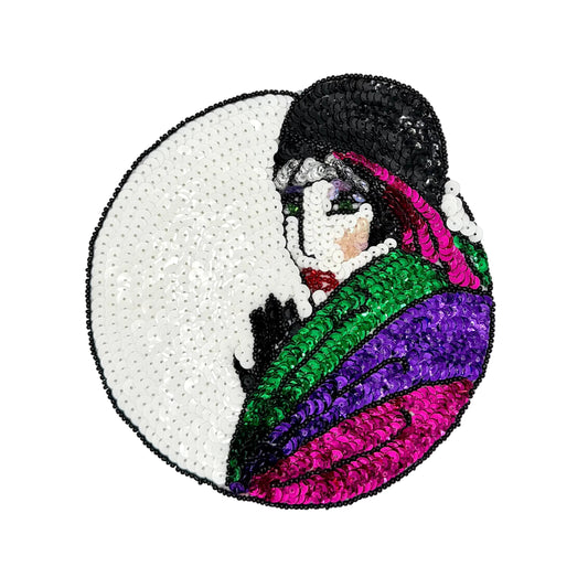 A circular sequined patch featuring a stylized portrait of a woman in profile with a black hat, green and purple draped fabric, and a white background.