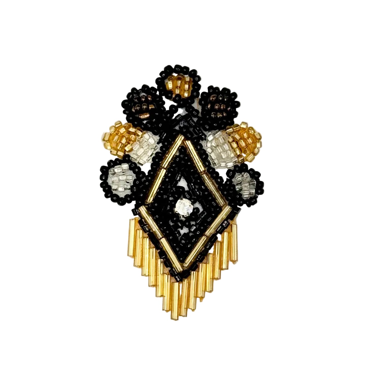 A handcrafted beaded crest design featuring a central diamond motif in black and gold beads, surrounded by floral clusters with black, white, and gold seed beads, and a fringe of gold beads at the bottom, displayed on a clean white background.