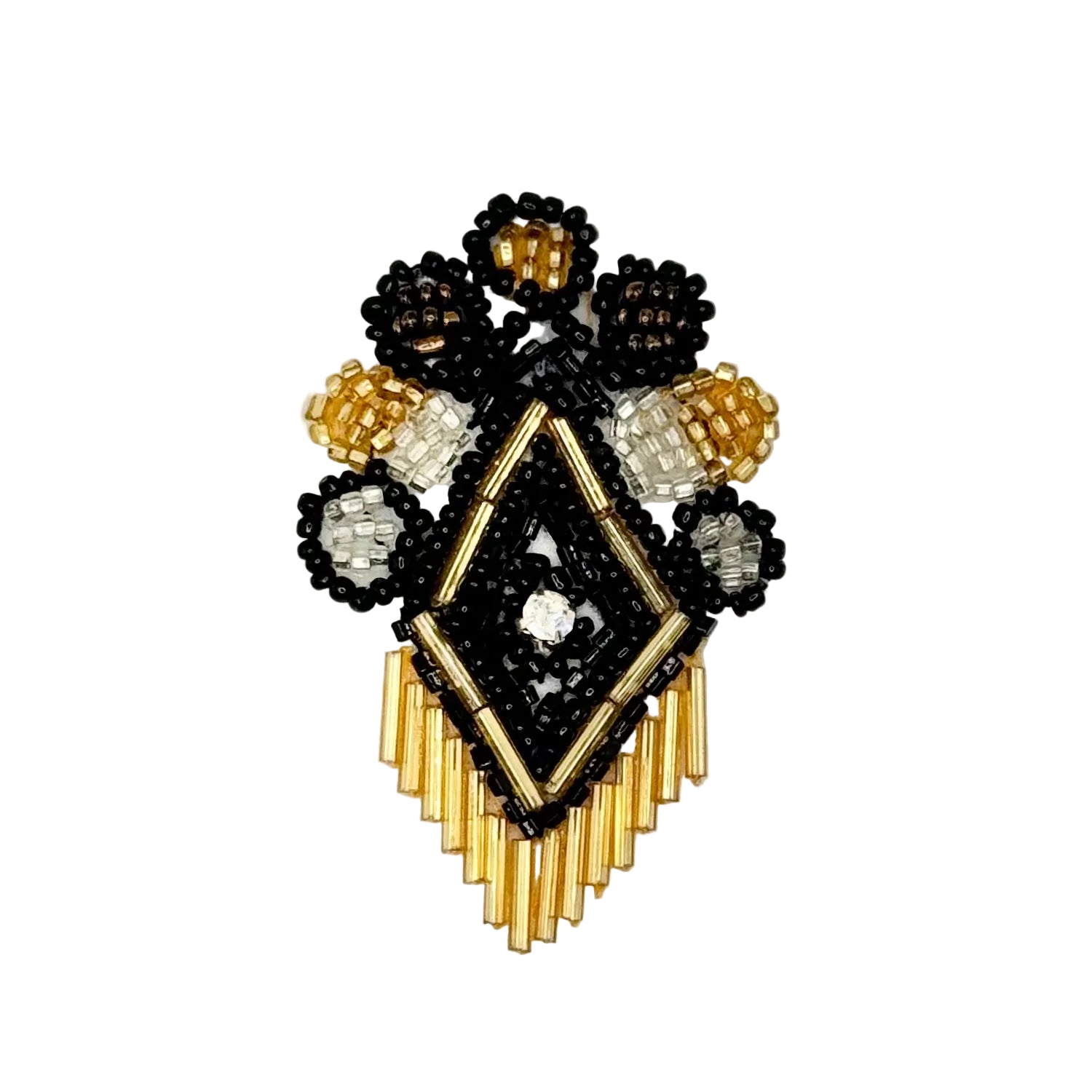 A handcrafted beaded crest design featuring a central diamond motif in black and gold beads, surrounded by floral clusters with black, white, and gold seed beads, and a fringe of gold beads at the bottom, displayed on a clean white background.