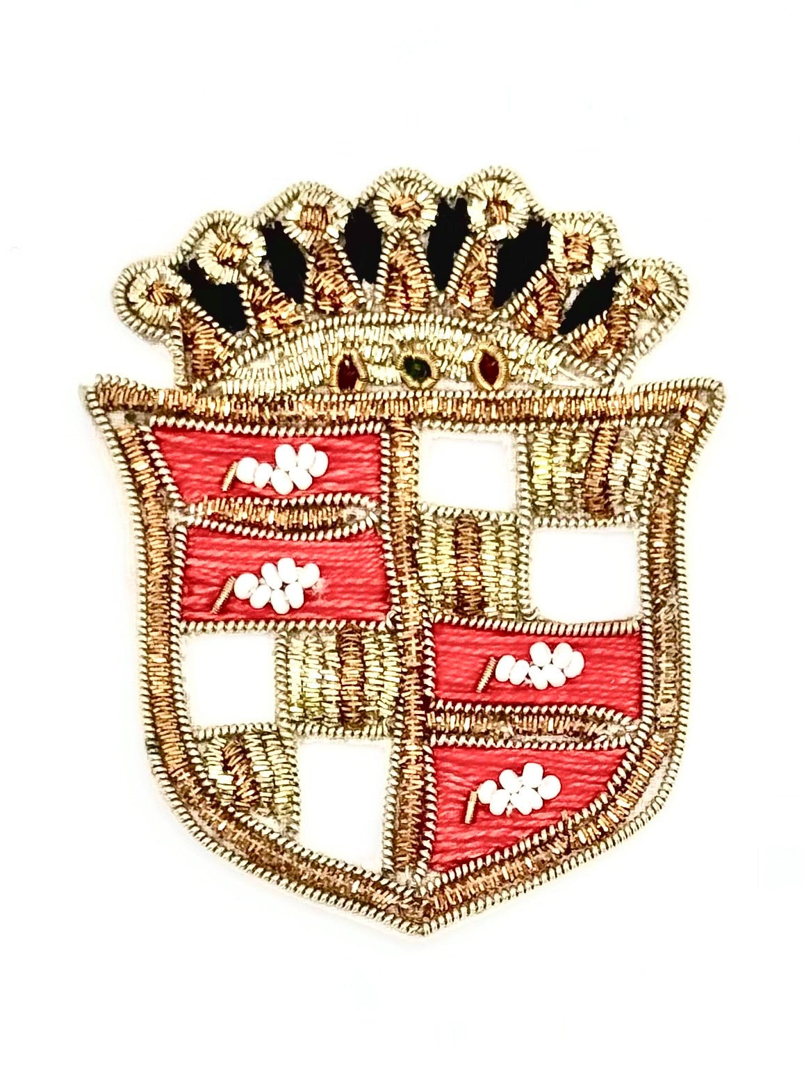 An embroidered shield-shaped patch with a gold-tone crown and border, featuring alternating red and open sections with small white floral motifs, shown on a plain white background.