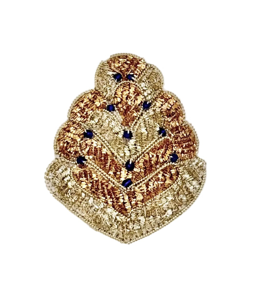 A decorative embroidered patch featuring a tiered, fan-like design in metallic gold and bronze threads, accented with small dark blue beads, set against a plain white background.