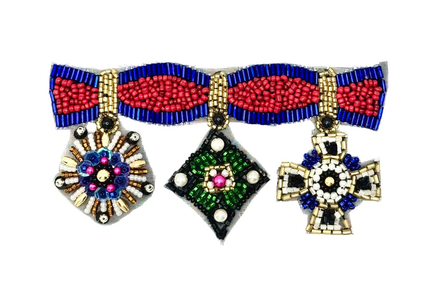 A beaded patch with three medals from a beaded ribbon : a sunburst design with gold, blue, pink, and white beads; a diamond-shaped pendant with green, black, white, and pink beads; and a cross pendant with gold, black, blue, and white beads, all shown on a plain white background.