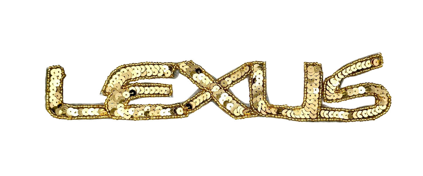 A vintage gold sequined patch spelling out the word 'LEXUS' in stylized lettering, shown on a plain white background.