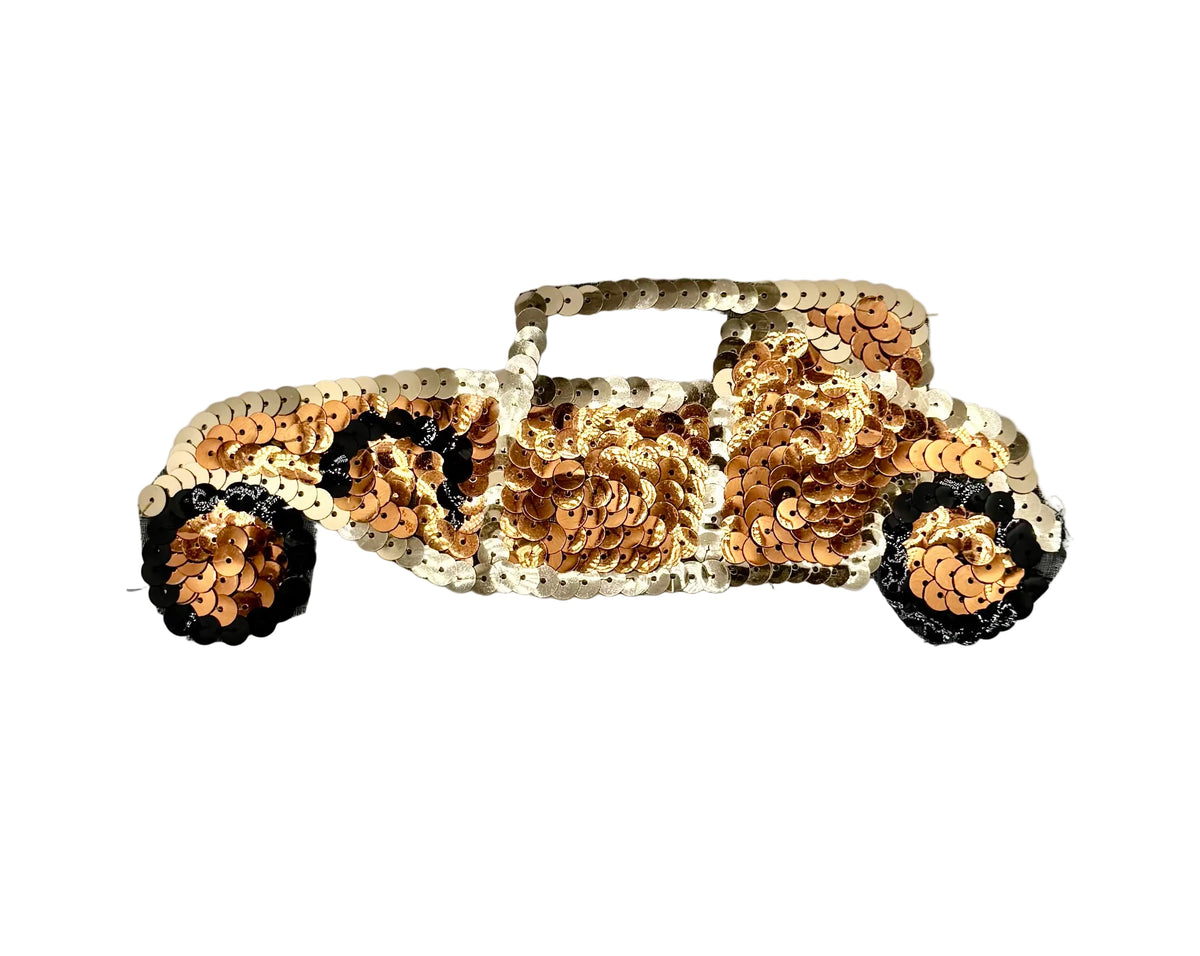 A sequined car-shaped applique or patch featuring a metallic rose gold and gold sequin pattern with black sequin accents on the wheels, shown on a plain white background.