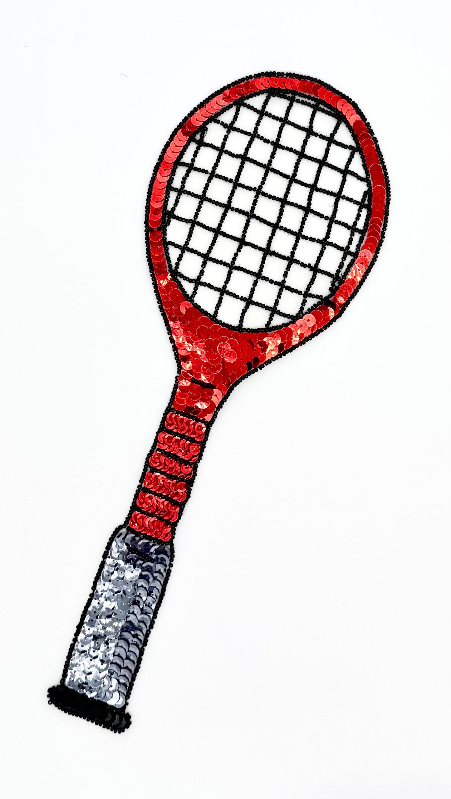 A stylized tennis sequin appliqué on a plain white background, with a red head and handle, black string bed, and a silver-gray wrapped grip.