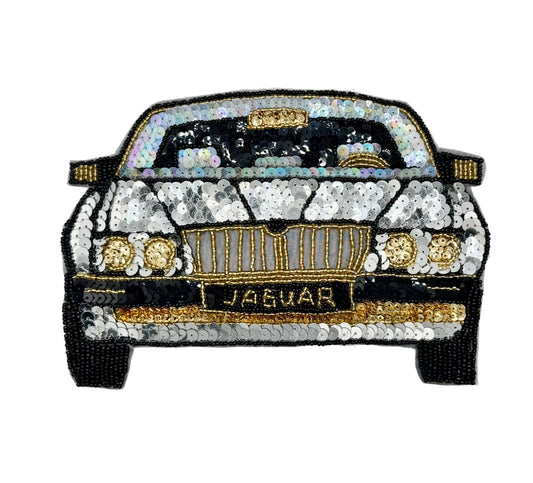 A vintage sequin and bead patch of a classic Jaguar car, decorated with iridescent sequins, gold beads, and black outlines, on a plain white background.
