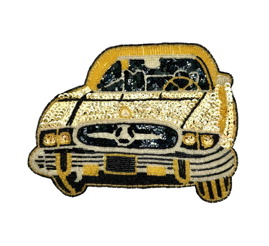A vintage embroidered patch of a vintage car in gold, black, and silver, shown on a plain white background.