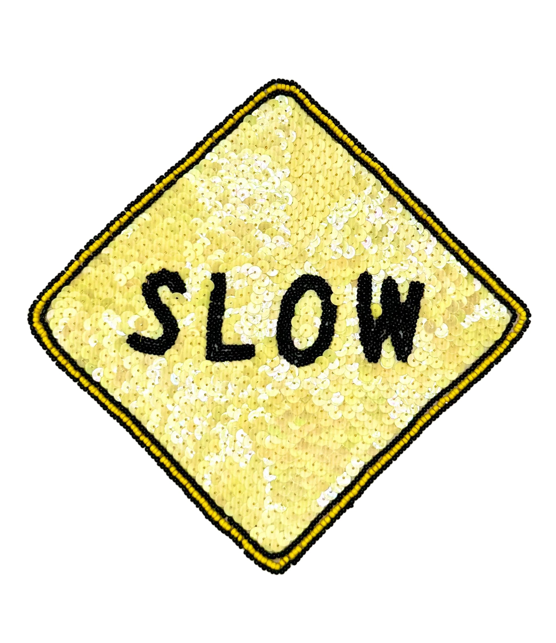 A diamond-shaped yellow patch with a black and yellow beaded border and the word 'SLOW' in black letters, shown on a plain white background.
