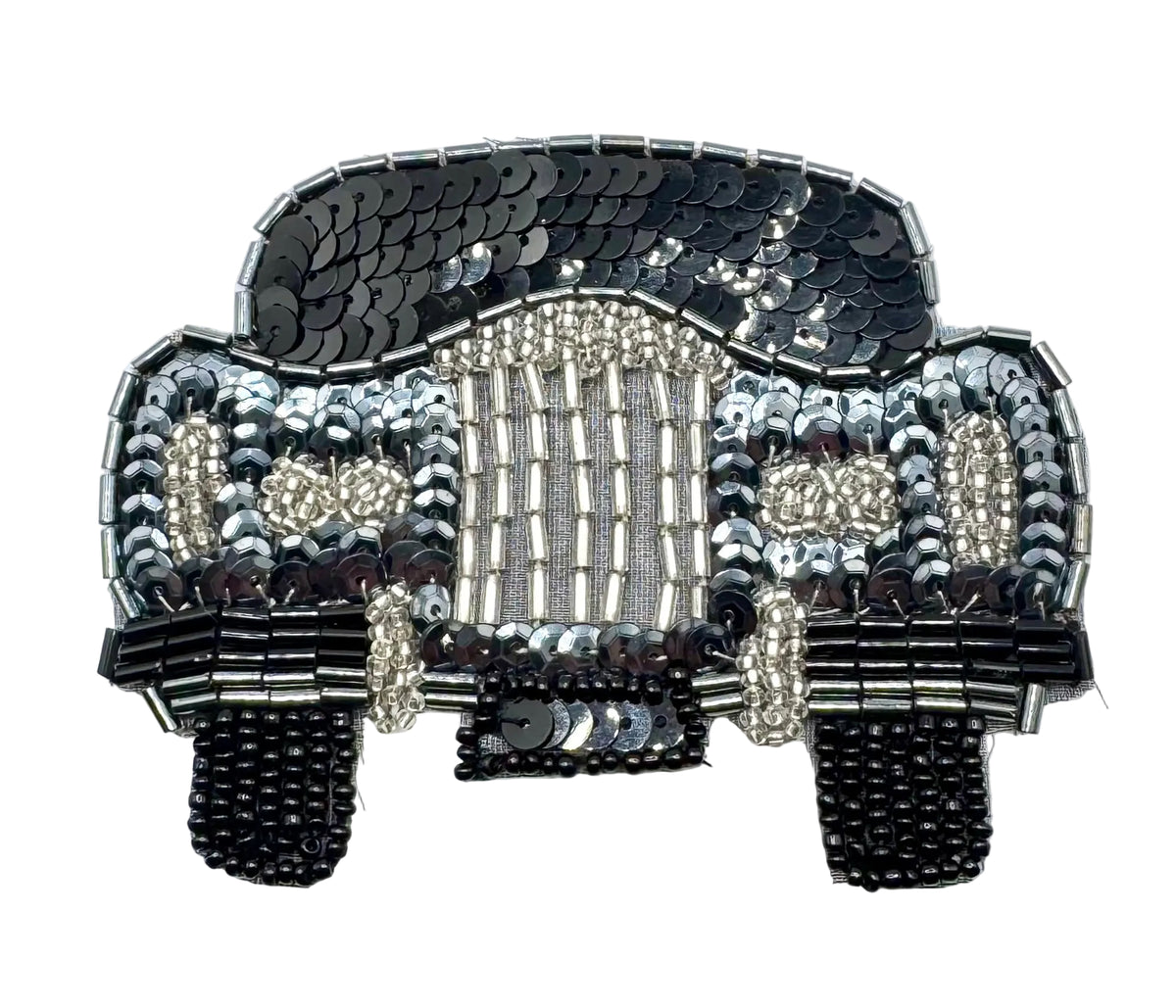 A decorative car-shaped embellishment or patch made from black and silver sequins, and beads, photographed on a plain white background.