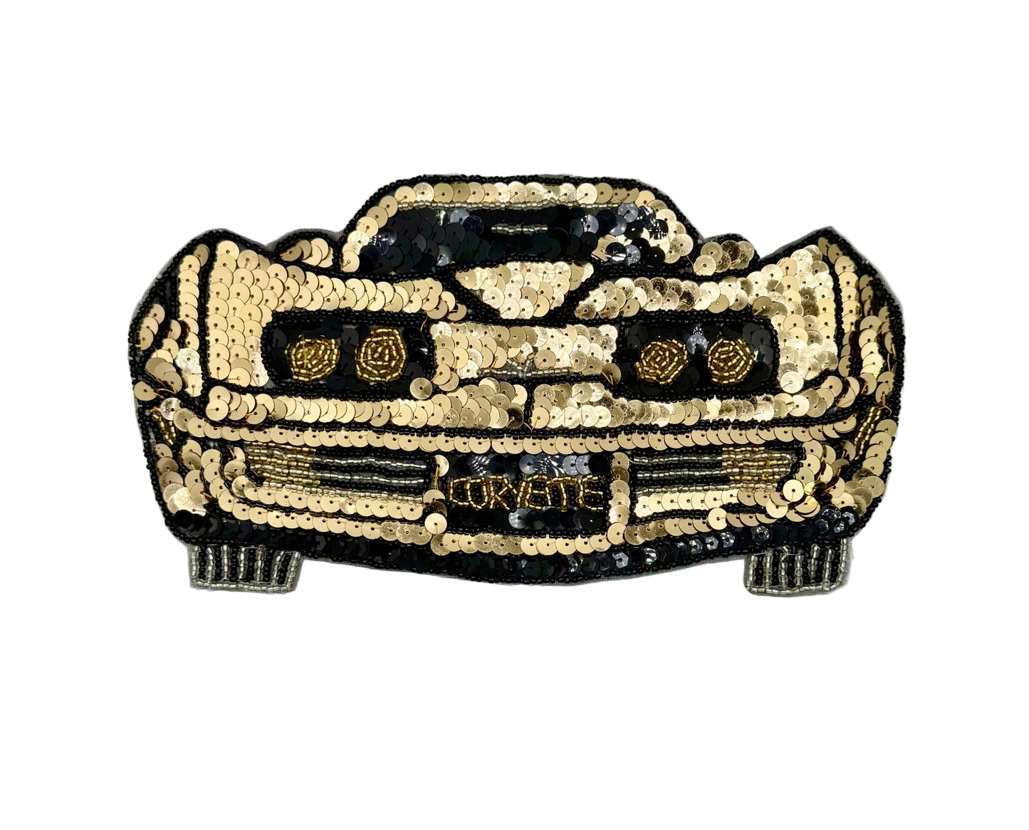 A decorative car-shaped vintage patch or applique made from gold and black sequins, with embroidered details and the word 'CORvette' across the front, shown on a plain white background.