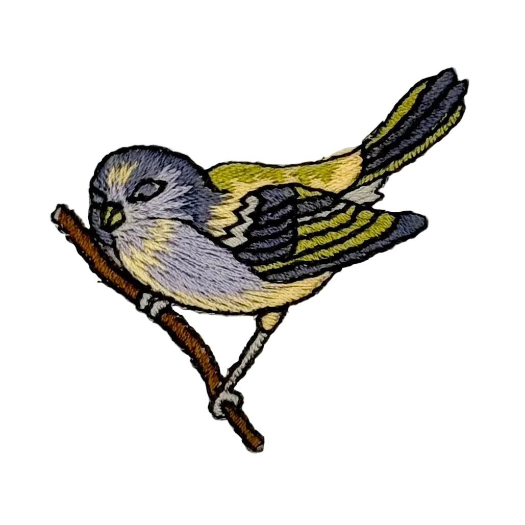 An embroidered bird patch of a small canary or finch perched on a brown branch, featuring yellow, gray, black, and white stitched details on a plain white background.