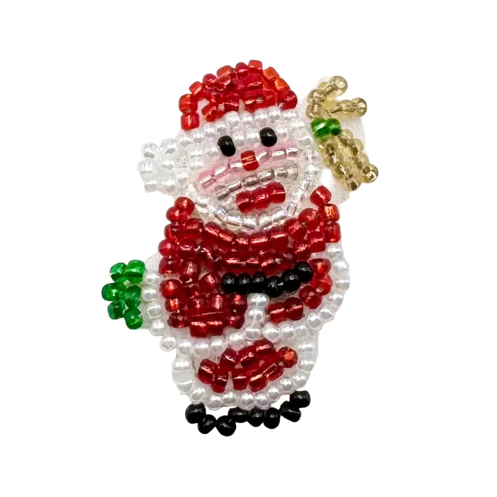 A handmade beaded Santa appliqué crafted with red, white, black, and green glass beads, carrying a bag of presents set against a plain white background.