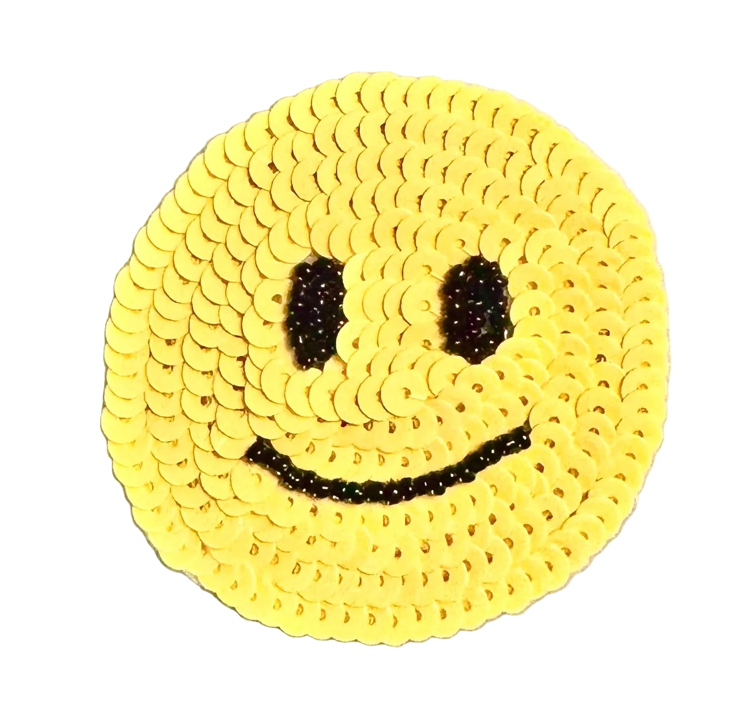 A round yellow smiley face decoration made from sequins, with black bead eyes and curved smile, shown on a white background.
