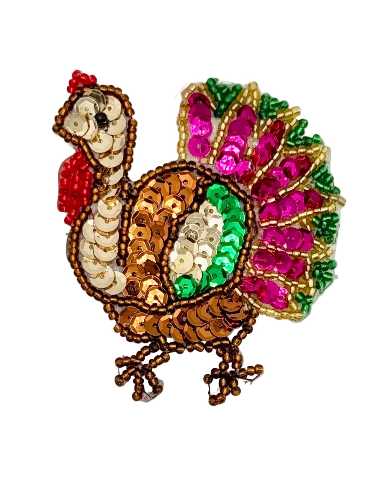 A decorative embroidered turkey applique or patch made with sequins and beads, featuring a brown body, gold neck, bright fuchsia and green tail feathers, and a red comb, shown on a white background.