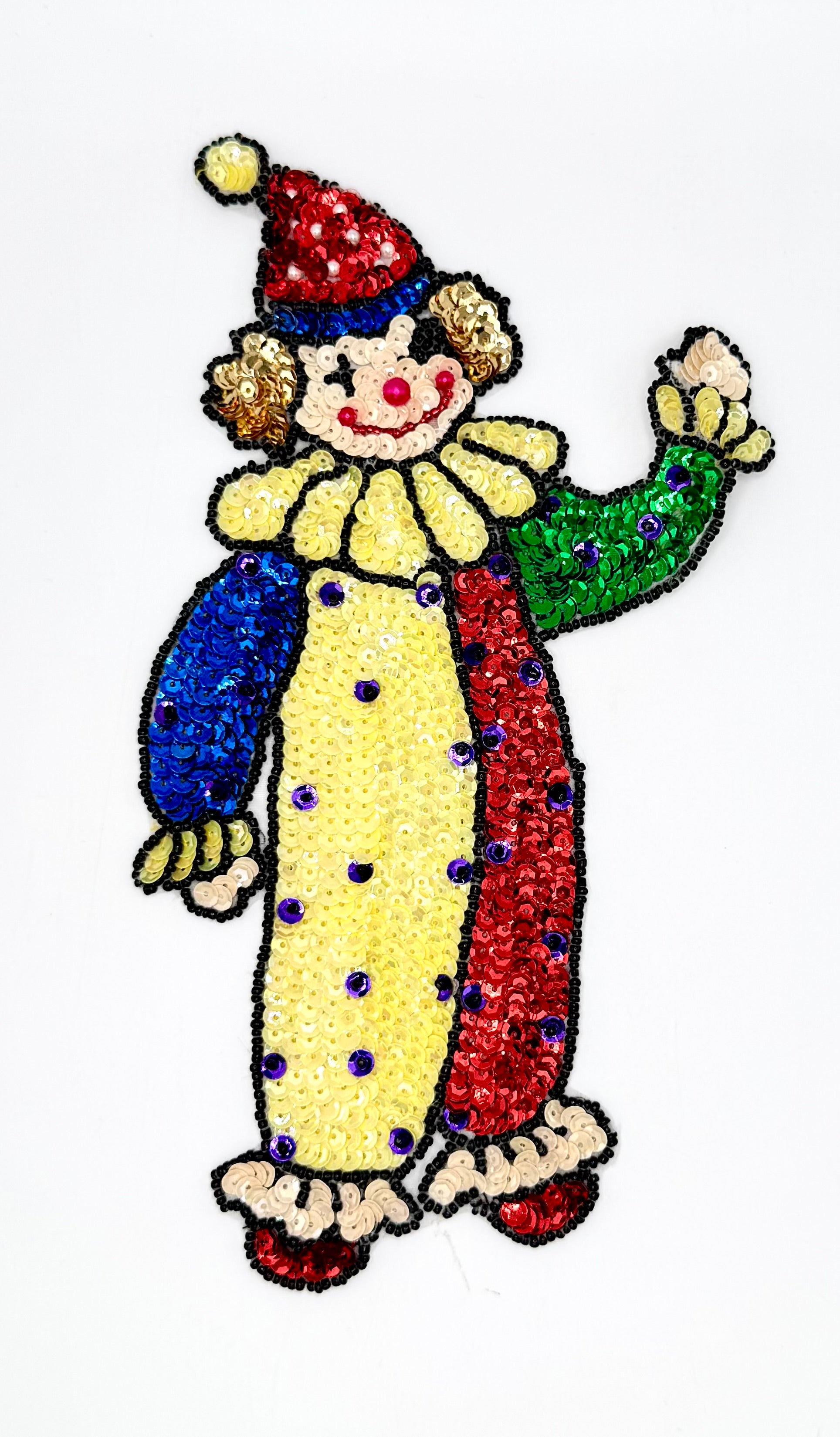 Colorful sequin clown figure with a red hat and yellow outfit on a white background