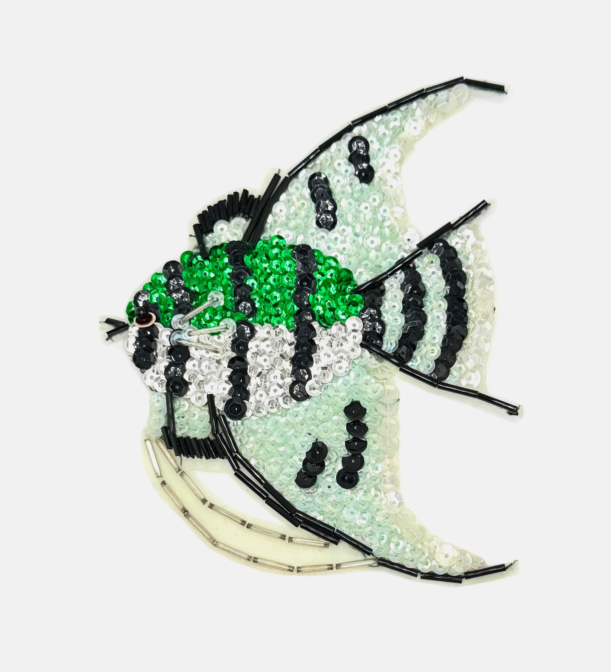 Decorative fish-shaped sequin patch with beads on a white background