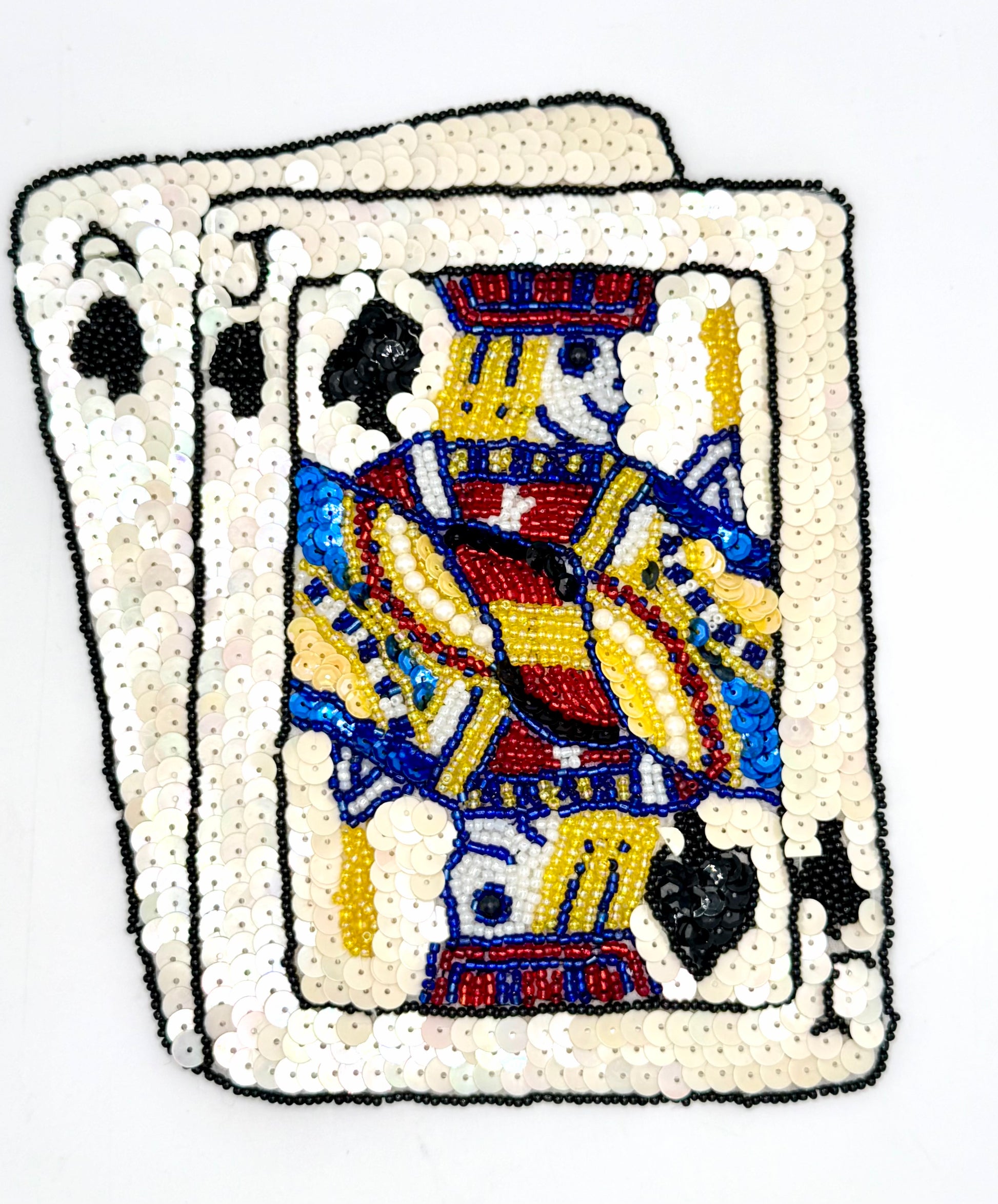 Sequined patch with an Ace and Jack of Spades on a white background