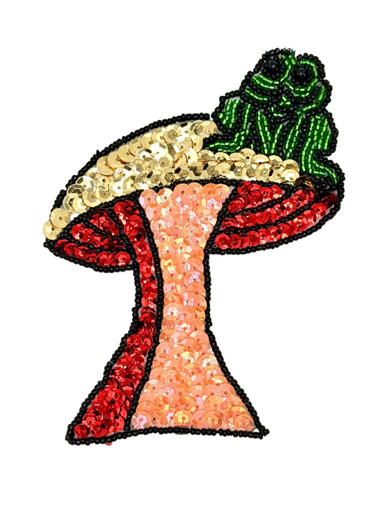 Colorful sequin patch of a mushroom with a green frog on a white background