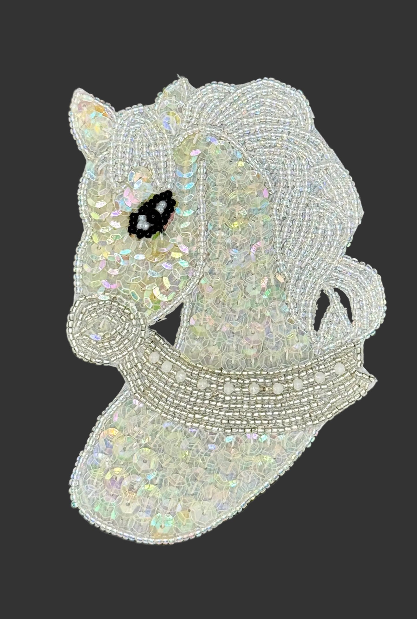 Iridescent beaded horse patch on a dark background